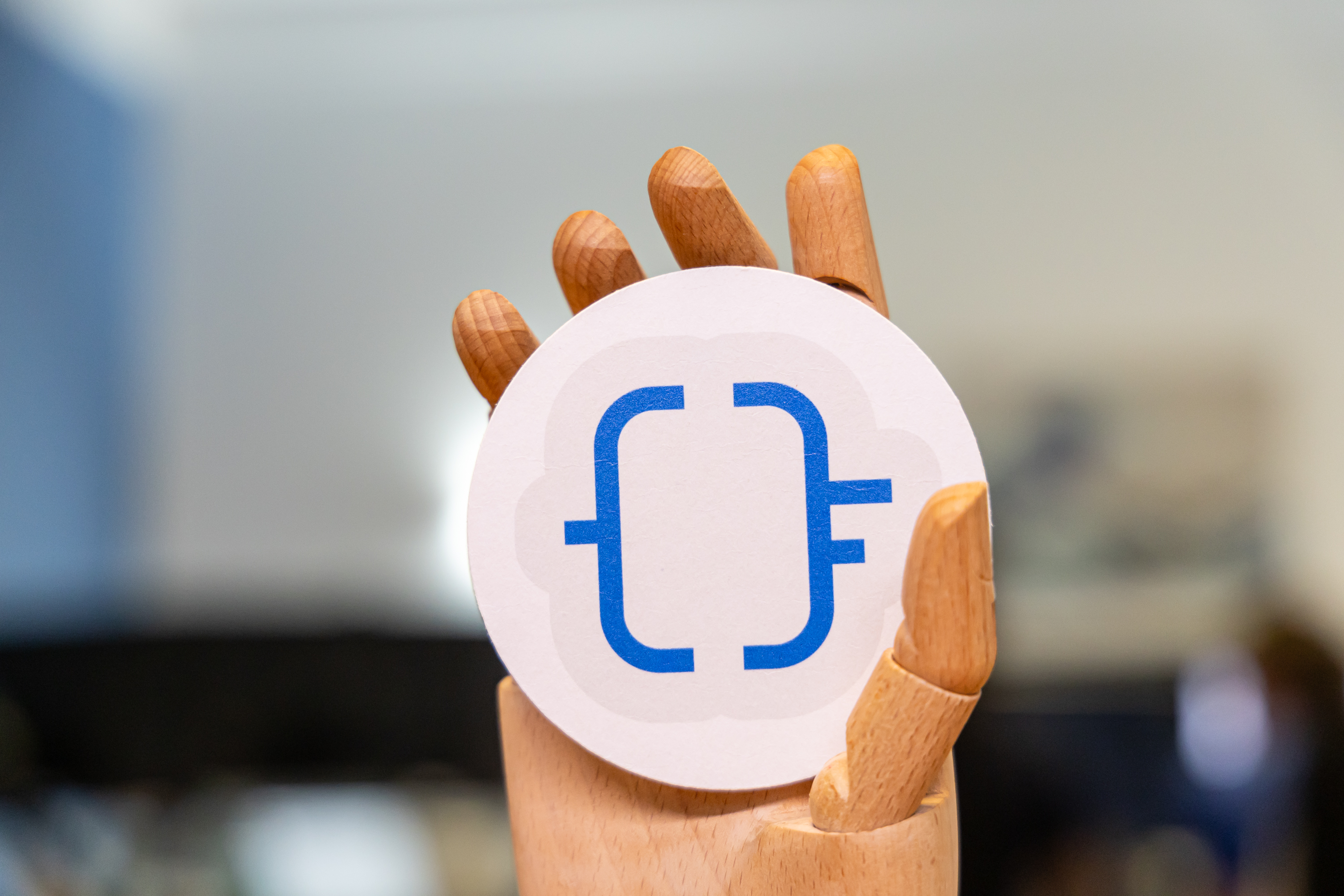 Alt text: wooden hand holding the optionfactory logo